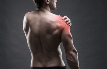 An athletic man suffering from shoulder joint pain.