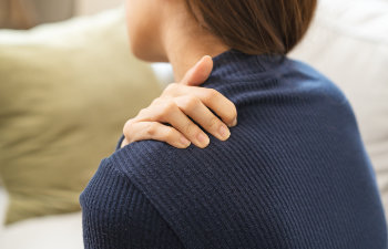 woman painful sitting on sofa at home